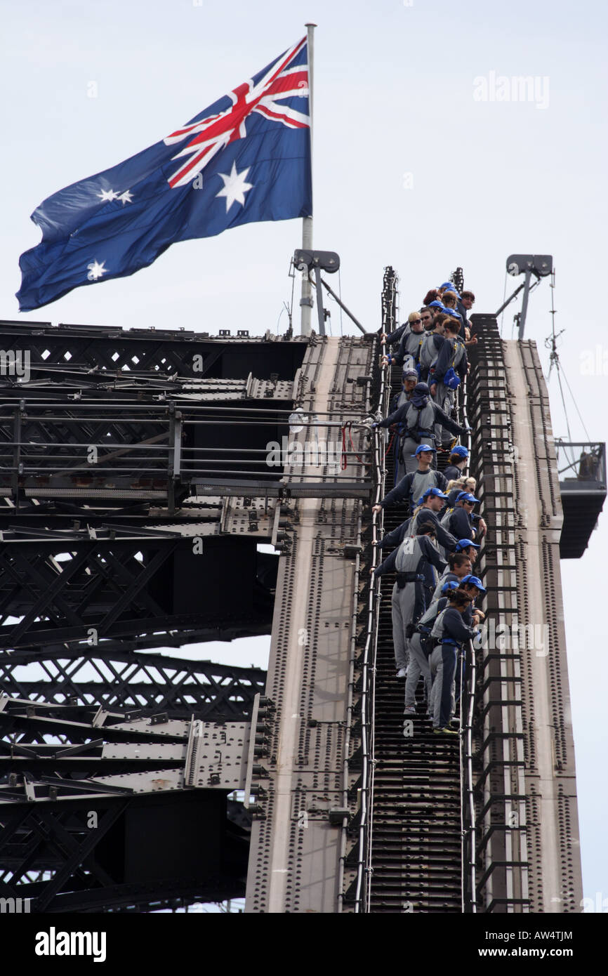 Bridge climbers on Sydney Harbour Bridge with Australian flag flying