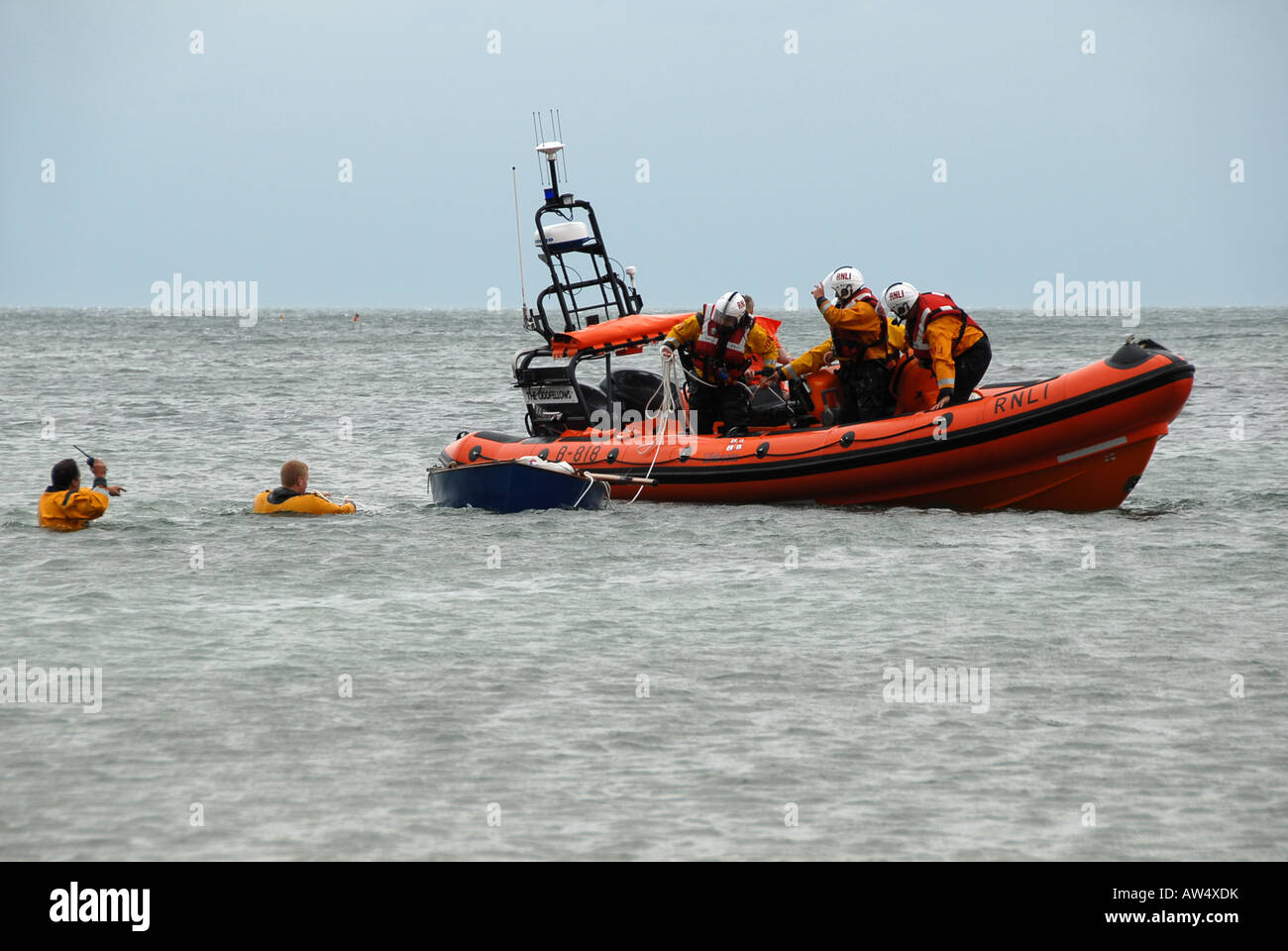 RNLI lifeboat pulling in capsized sailing dinghy Sheringham beach