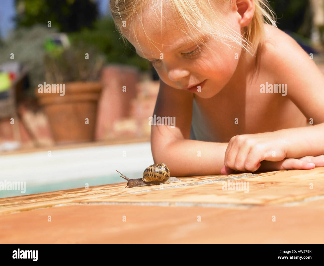 Little girl looking at a snail. Stock Photo