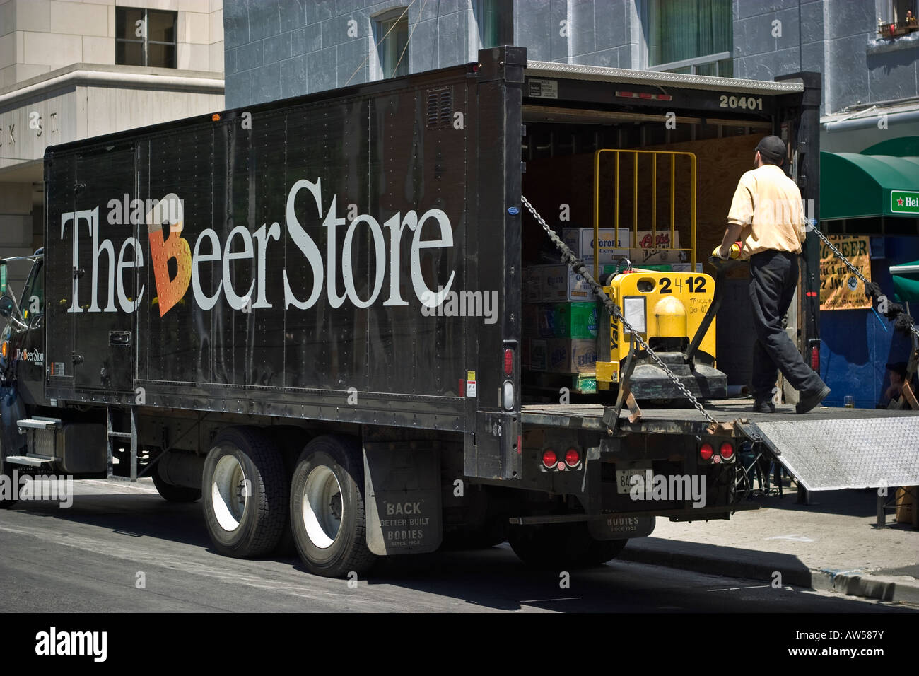 Worker unloading beer crates from delivery truck using Yale motorized hand trucks Stock Photo