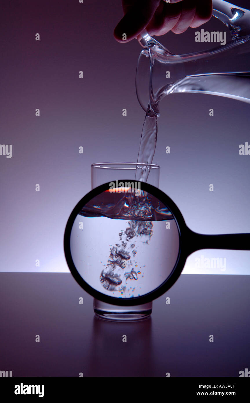 Water jug pouring into glass with magnifier Stock Photo Alamy
