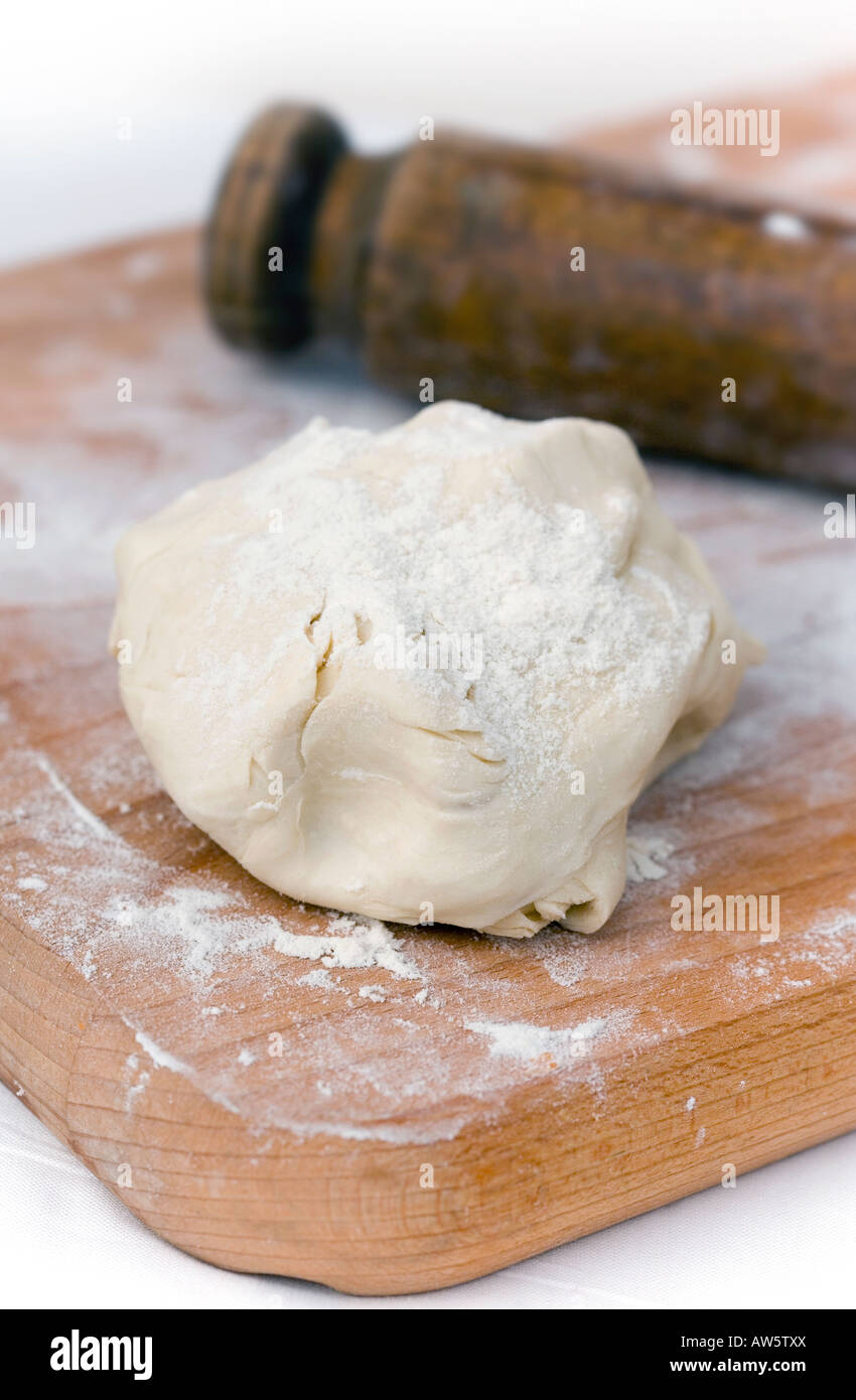 Puff pastry dough with a vintage rolling pin. Stock Photo