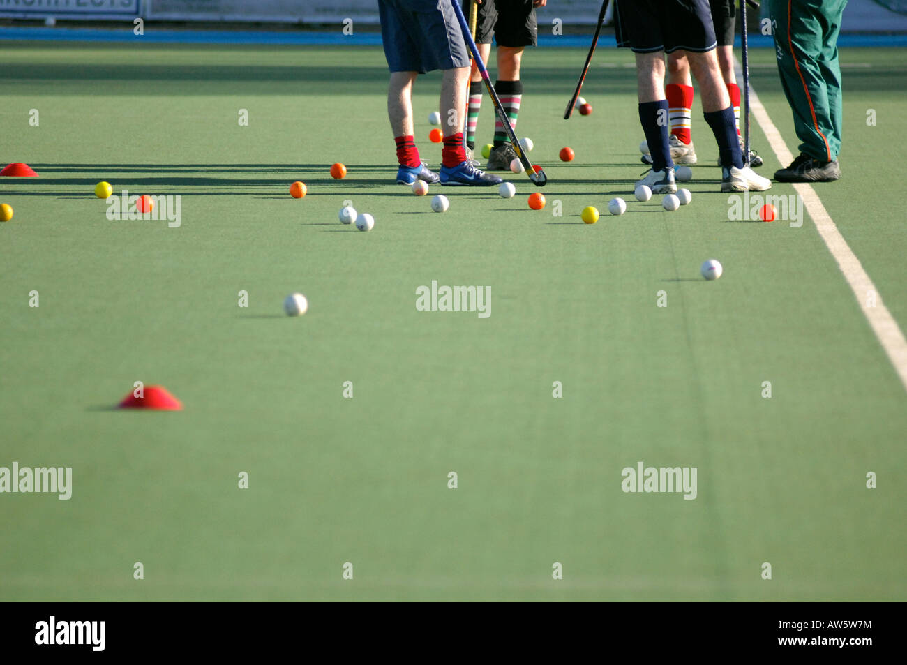 Photograph of college hockey players in training practice on hockey field and talking tactics with coach UK London. Stock Photo