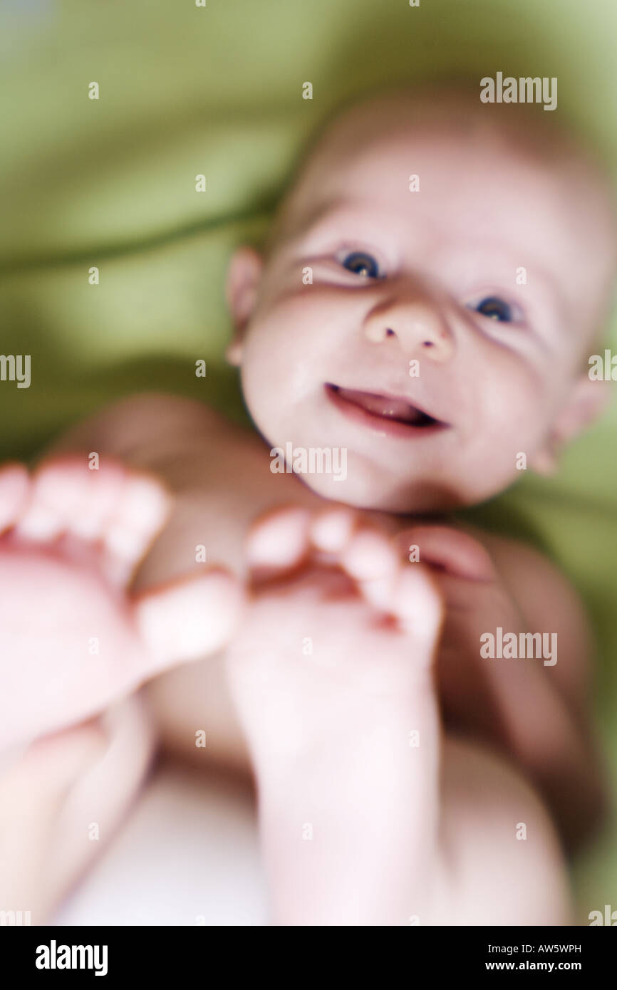 A silly baby discovers his feet for the first time Stock Photo Alamy