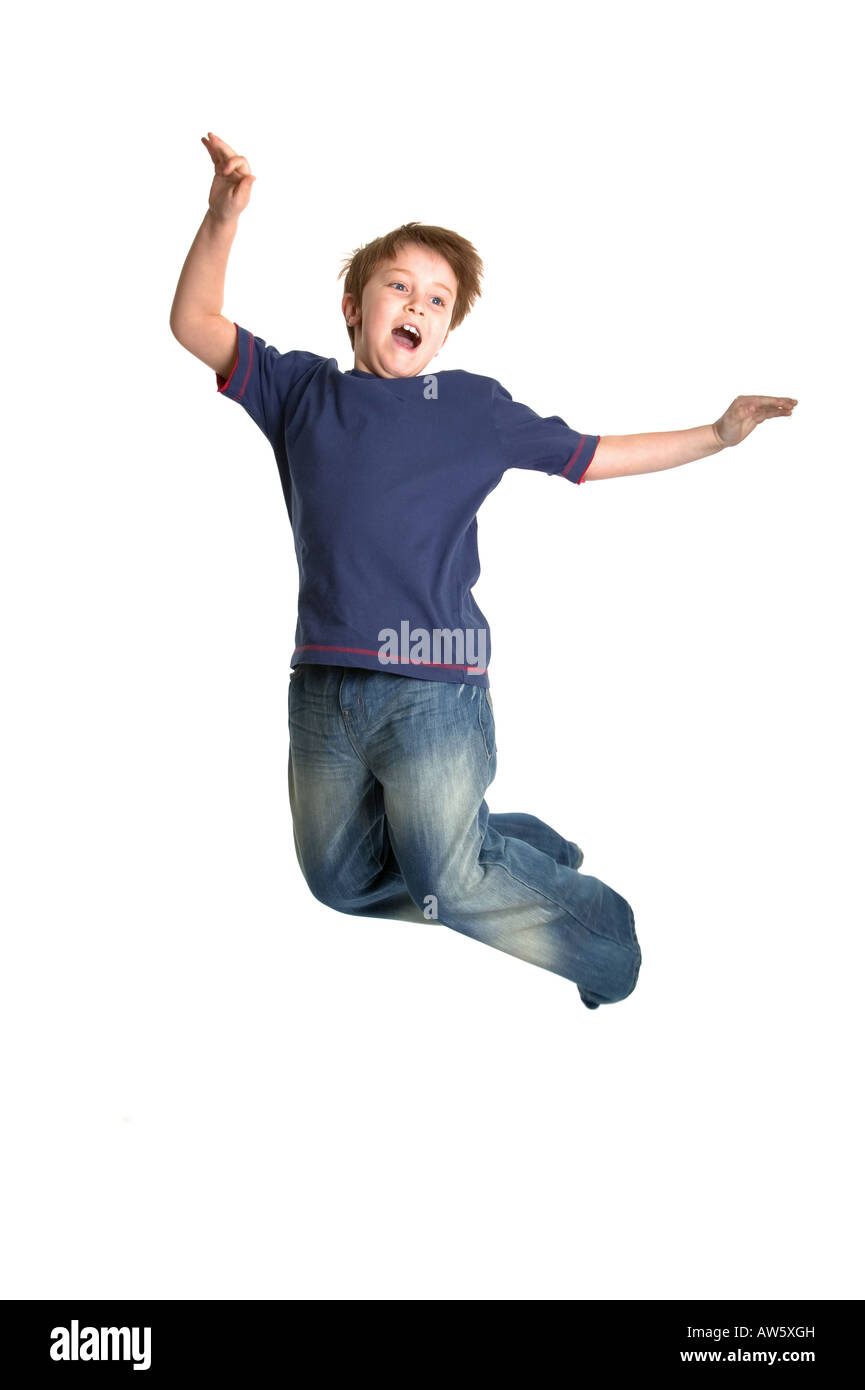 A happy young boy jumping in the air against a white background Very slight motion blur Stock Photo