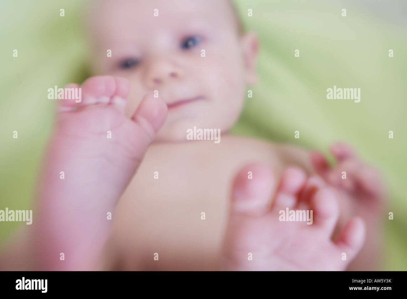 A silly baby discovers his feet for the first time Stock Photo Alamy