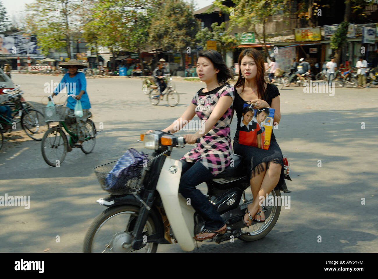 Two young women are driving around on their motor bike, enjoying some shopping Stock Photo