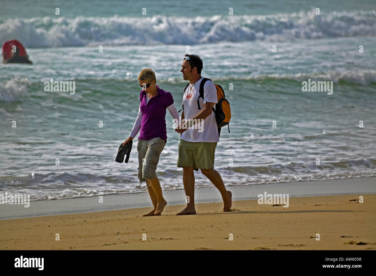 Male and female walk hand in hand along sandy  beach, Hossegor, France, Europe Stock Photo