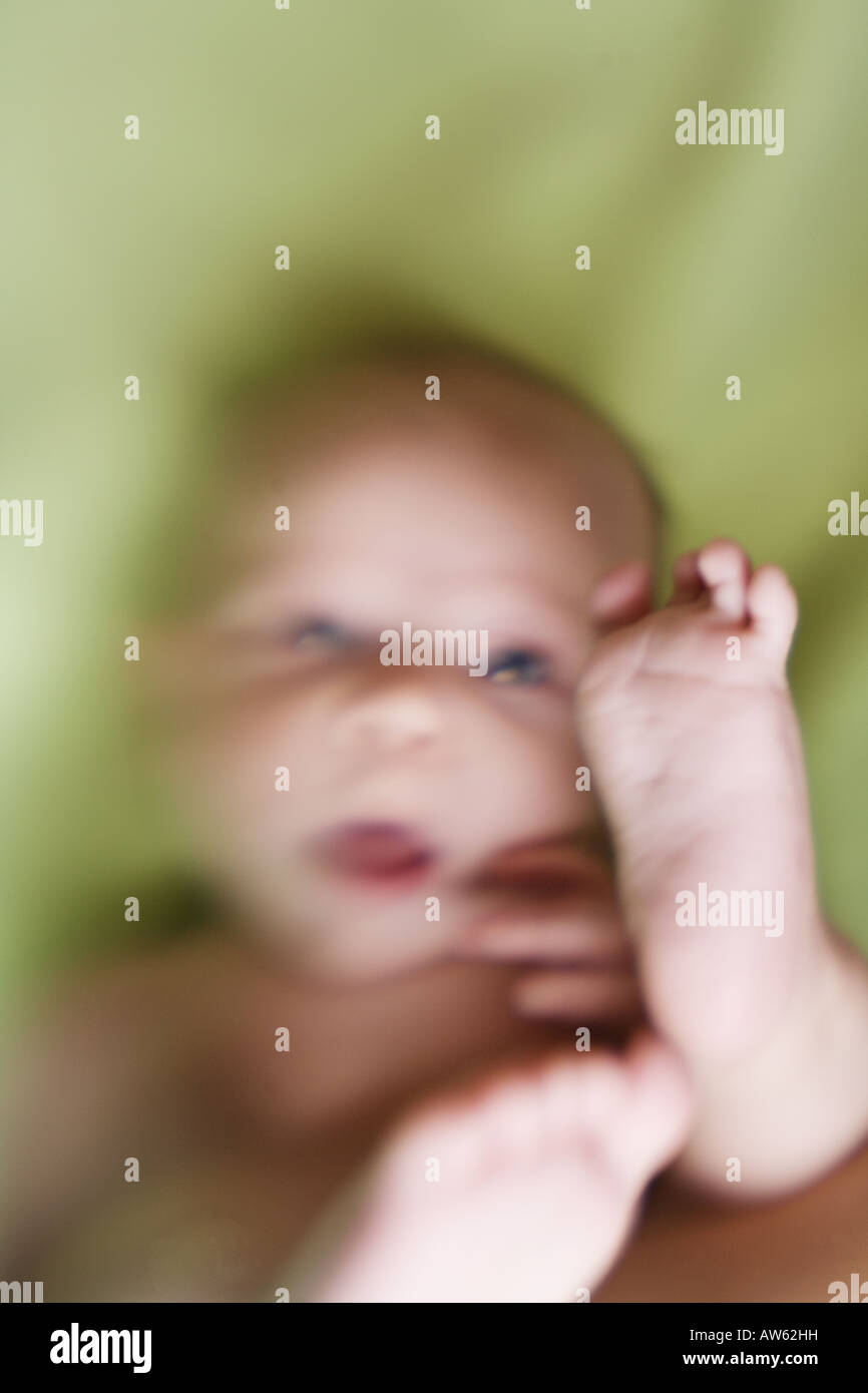 A silly baby discovers his feet for the first time Stock Photo Alamy