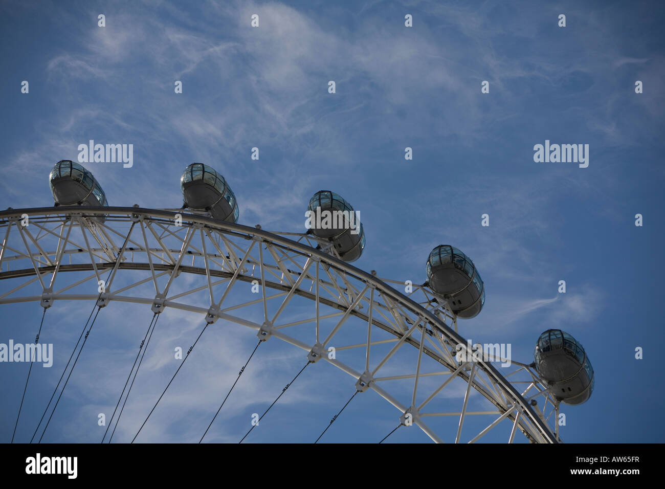 The British Airways London Eye tourist attraction on the south bank of the River Thames in London with a blue sky and cirrus clo Stock Photo