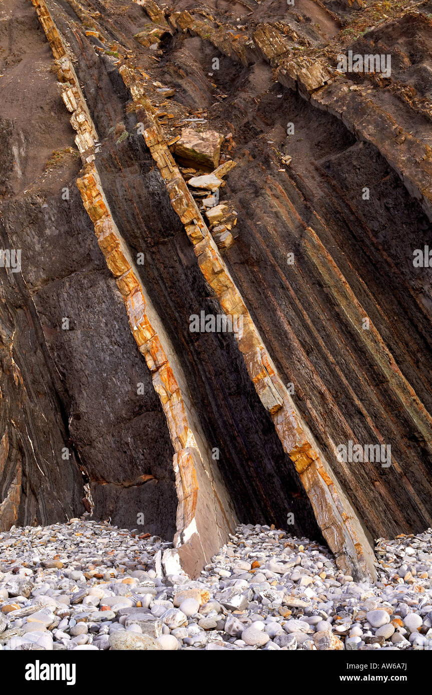 Multiple layers of eroded cliff in a pebbles beach Stock Photo