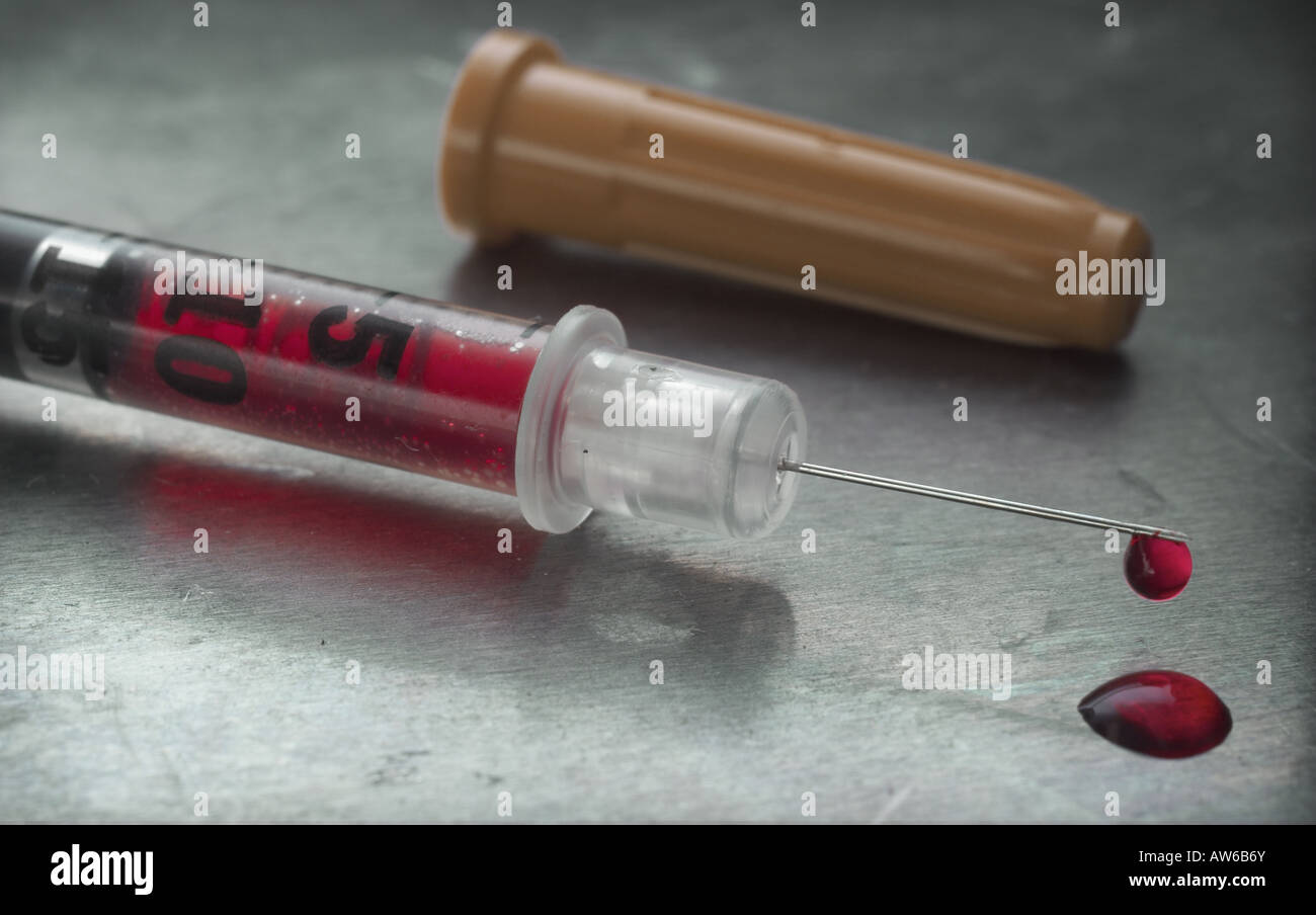 Hypodermic syringe dripping blood Stock Photo