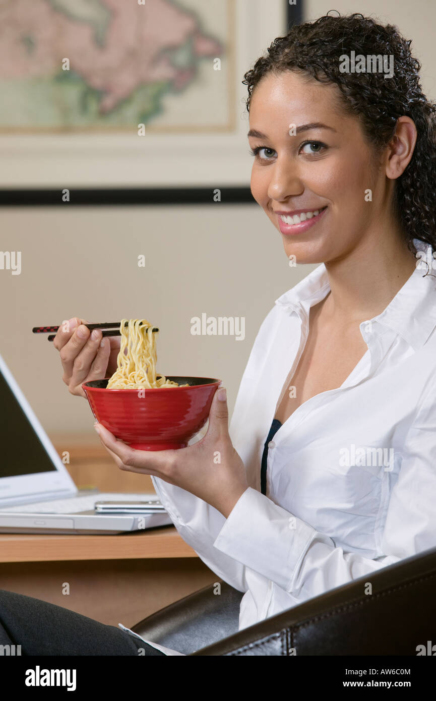 Woman eating Asian noodles with chopsticks Stock Photo