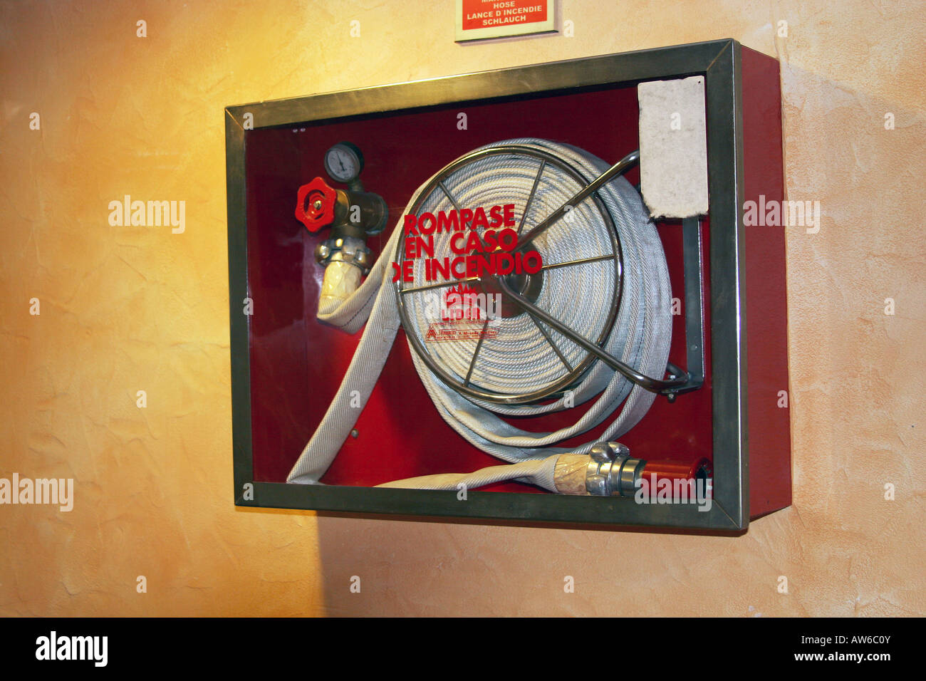 Hose reel mounted in a hotel corridor for emergency use in case of fire Stock Photo Alamy