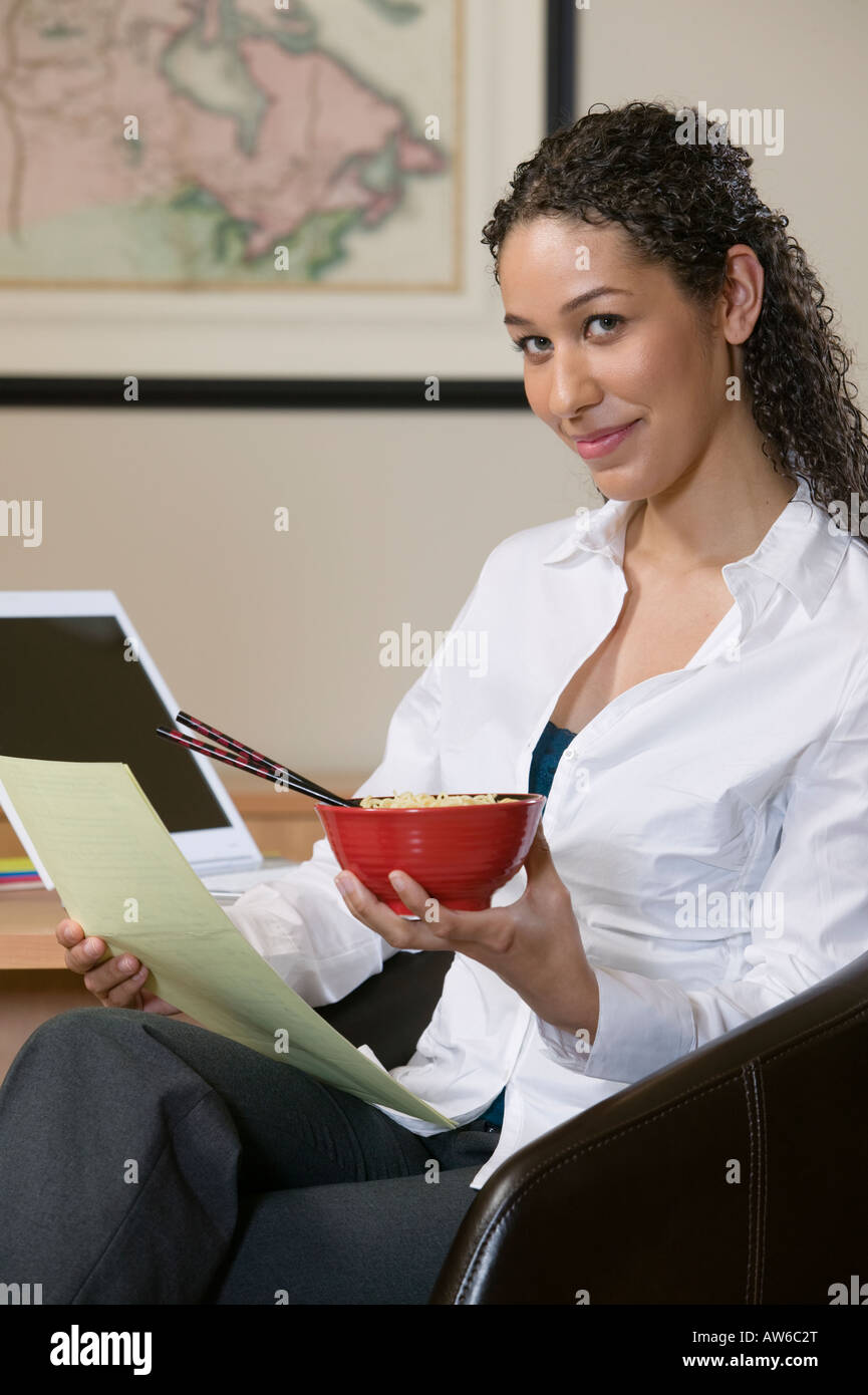 Woman eating Asian noodles with chopsticks Stock Photo