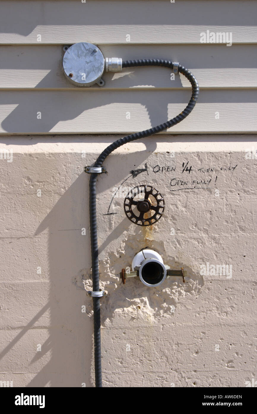 Electric wire attached to basement wall of house. Photo by Willy Matheisl Stock Photo