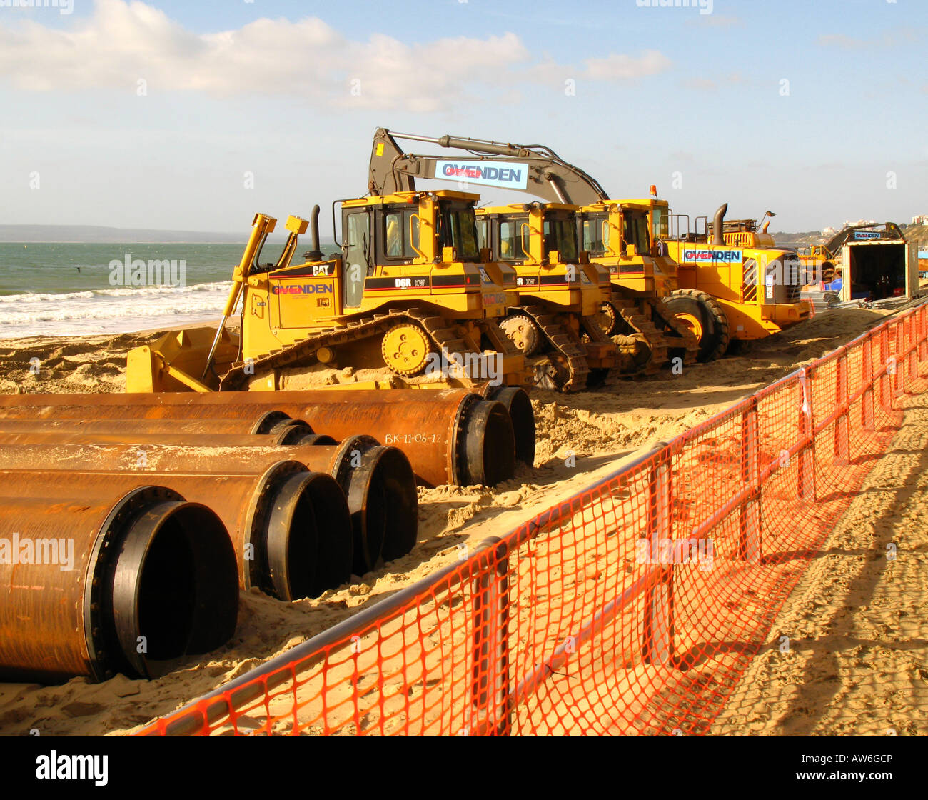 Construction vehicles on Boscombe beach, Bournemouth, Britain, seprated from pedestrian area by orange netting. Stock Photo