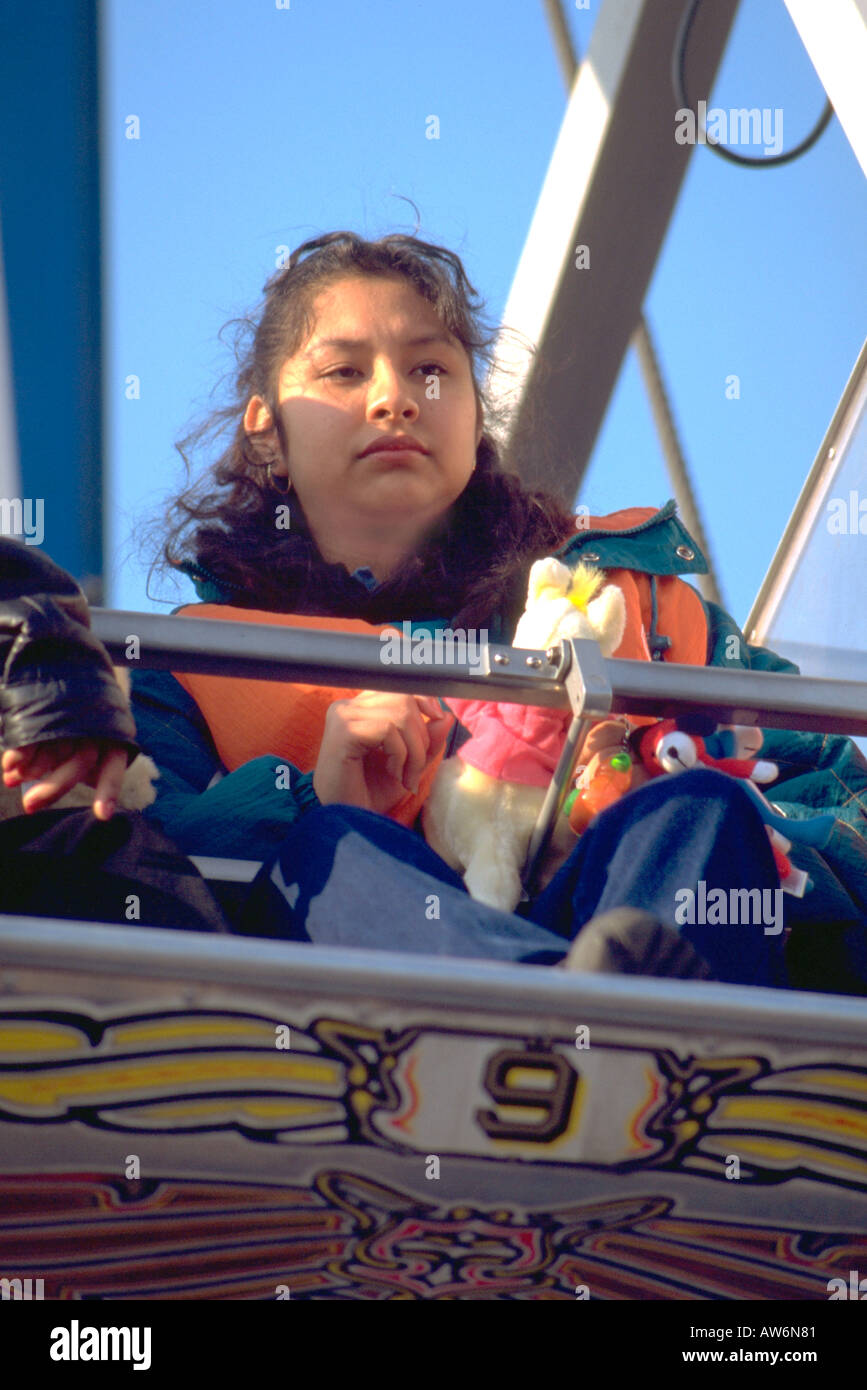 Woman age 20 riding on a carnival thrill ride. Cinco de Mayo Festival and Parade Chicago Illinois USA Stock Photo