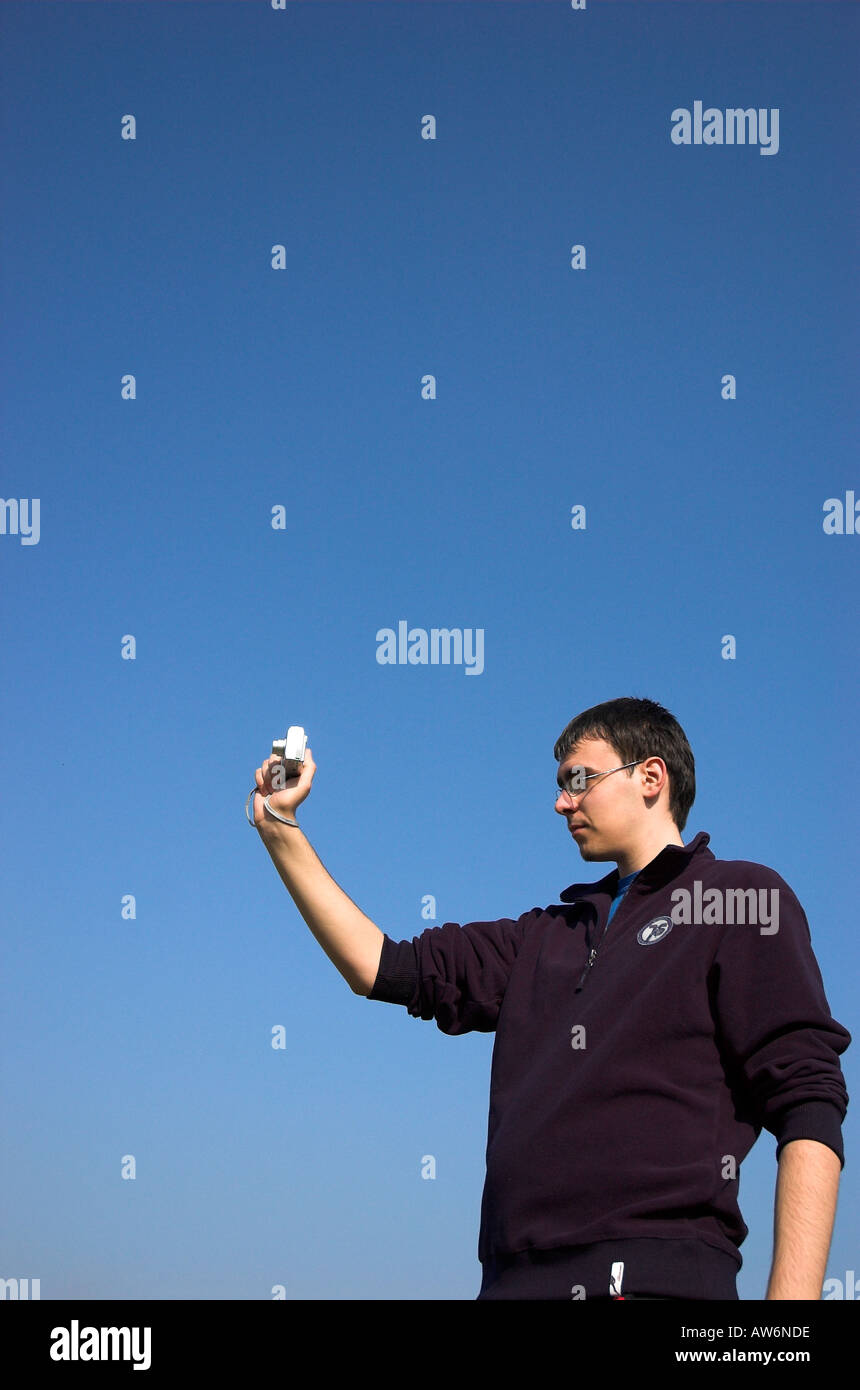 Young man holding digital camera Stock Photo