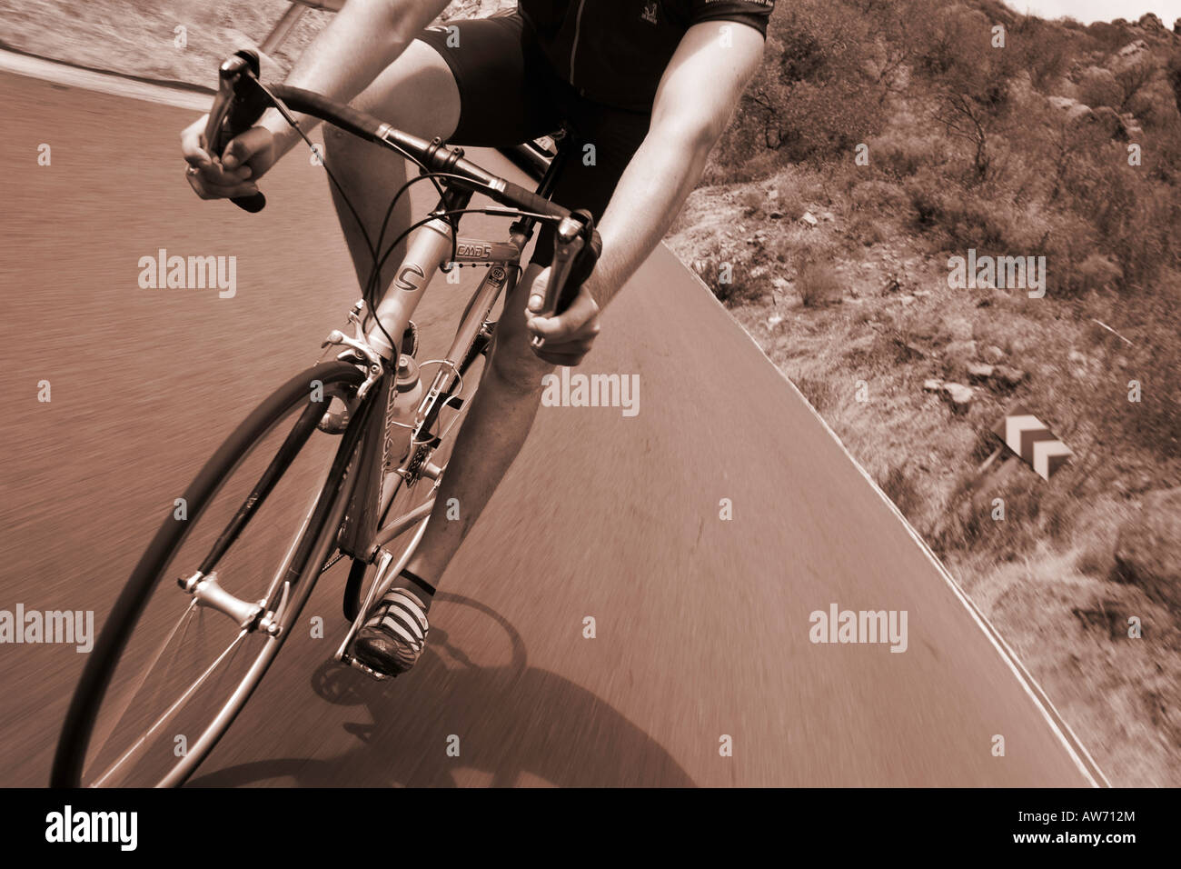 A road biker, on a Cannondale bike, is taking a high speed turn on the ...
