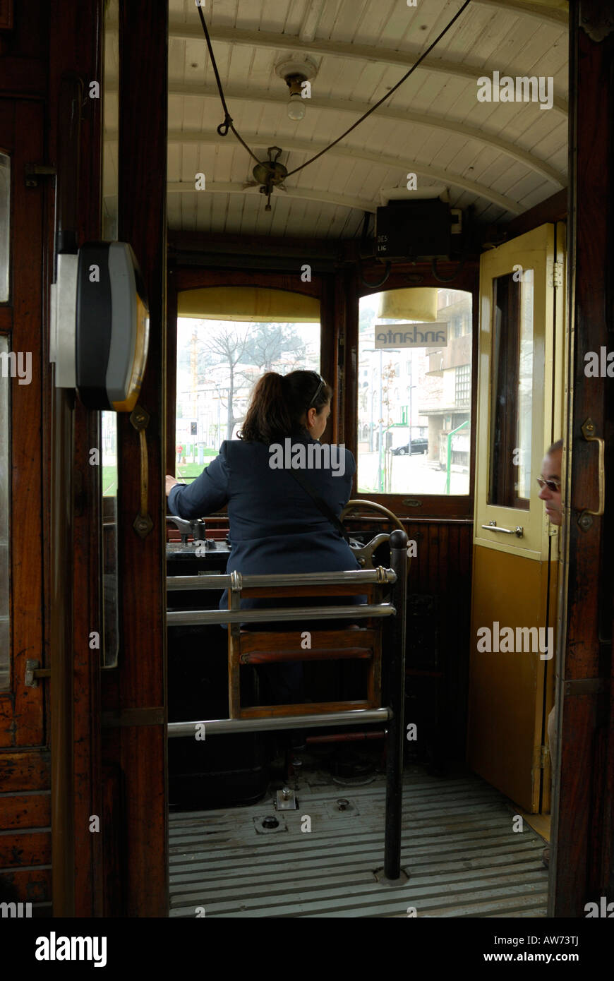 Rear view of a woman driving a tram that runs along a coastal route in Porto, Portugal Stock Photo