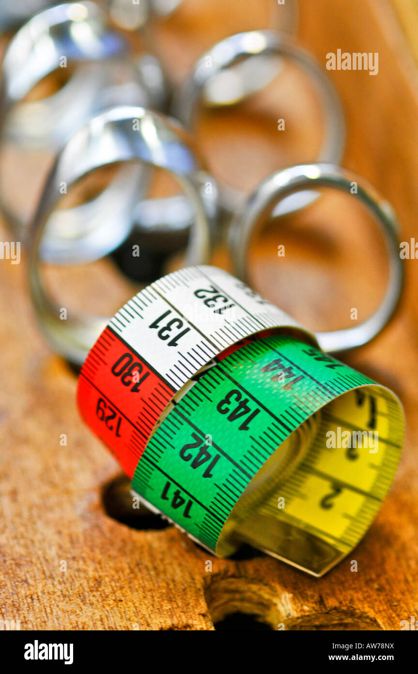 A tape measure  rolled with scissors in the background Stock Photo