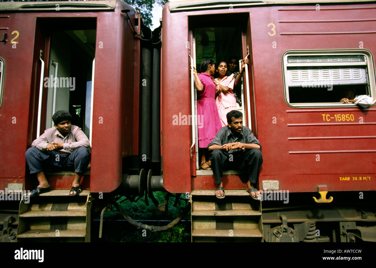 Sri Lanka railway transport train passengers sitting on steps waiting for departure Stock Photo