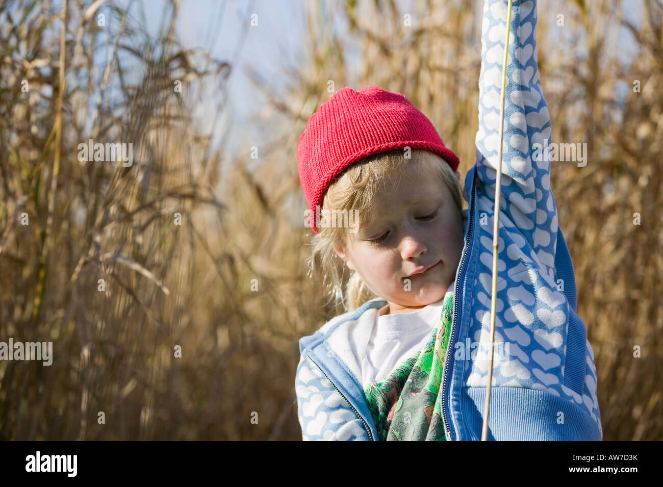 Girl with red hat in tall grass field Stock Photo