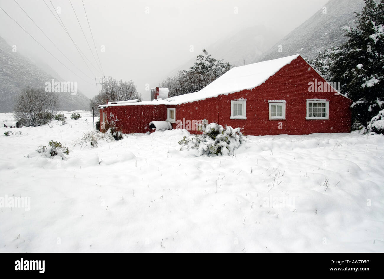 A red farm building in the snow at Arthurs Pass, Canterbury, New Zealand Stock Photo