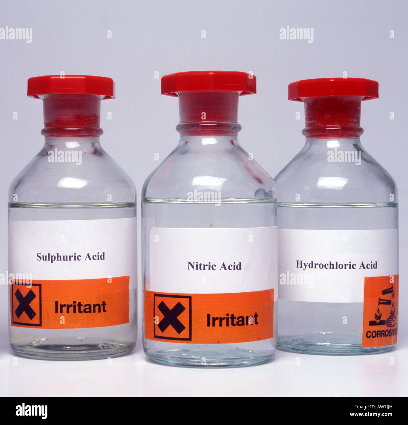 Bottles of laboratory acids with hazard labels Stock Photo - Alamy