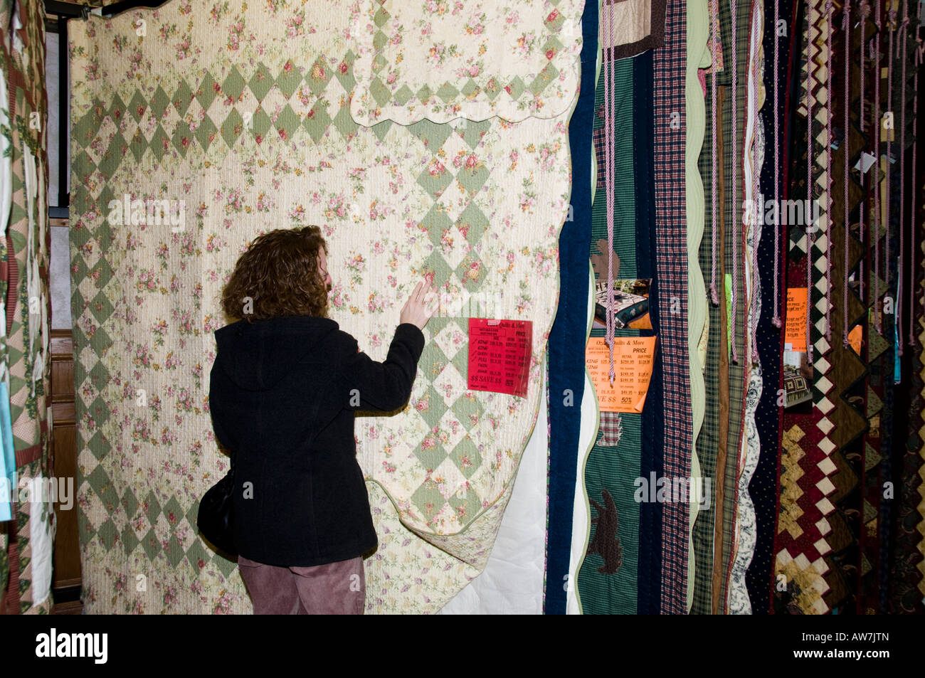 A caucasian woman looks at quilts in Branson, Missouri. Stock Photo