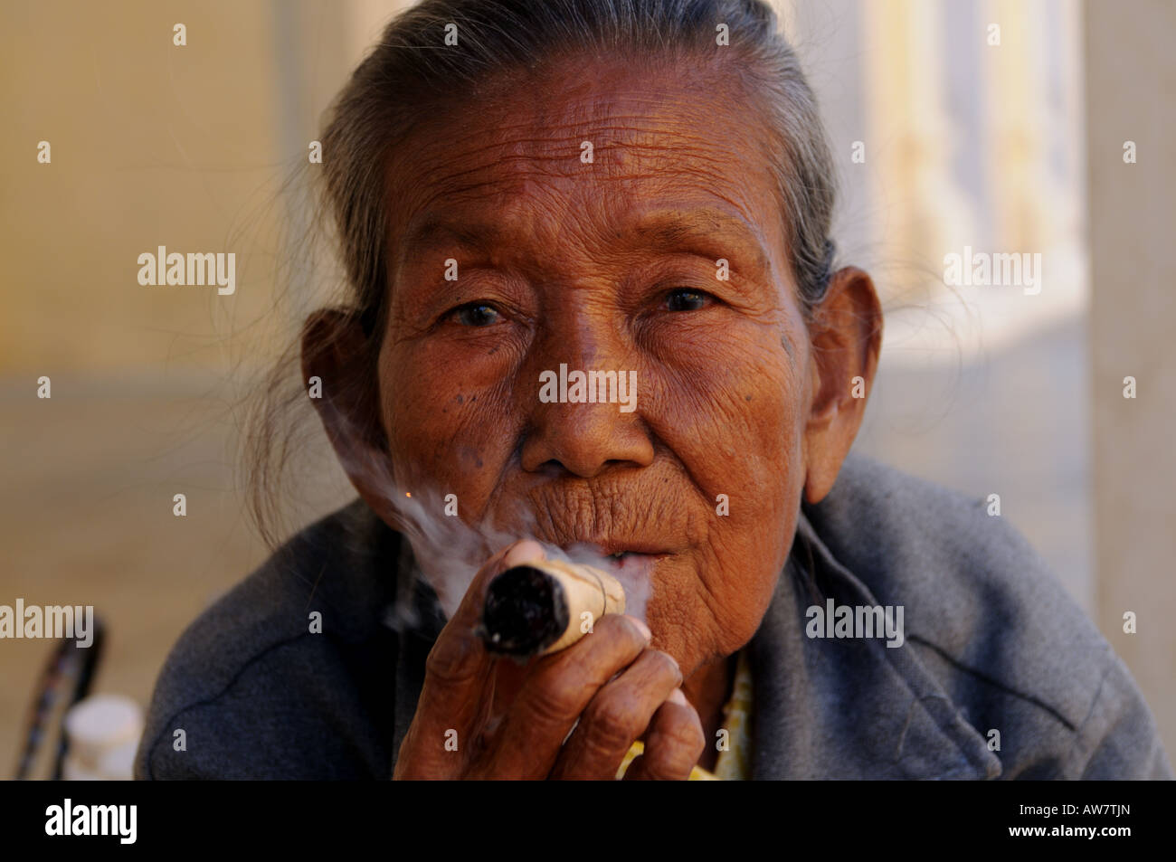 Old woman smokes a Marihuana Cigar Cigarette Bagan Myanmar Asia Stock Photo