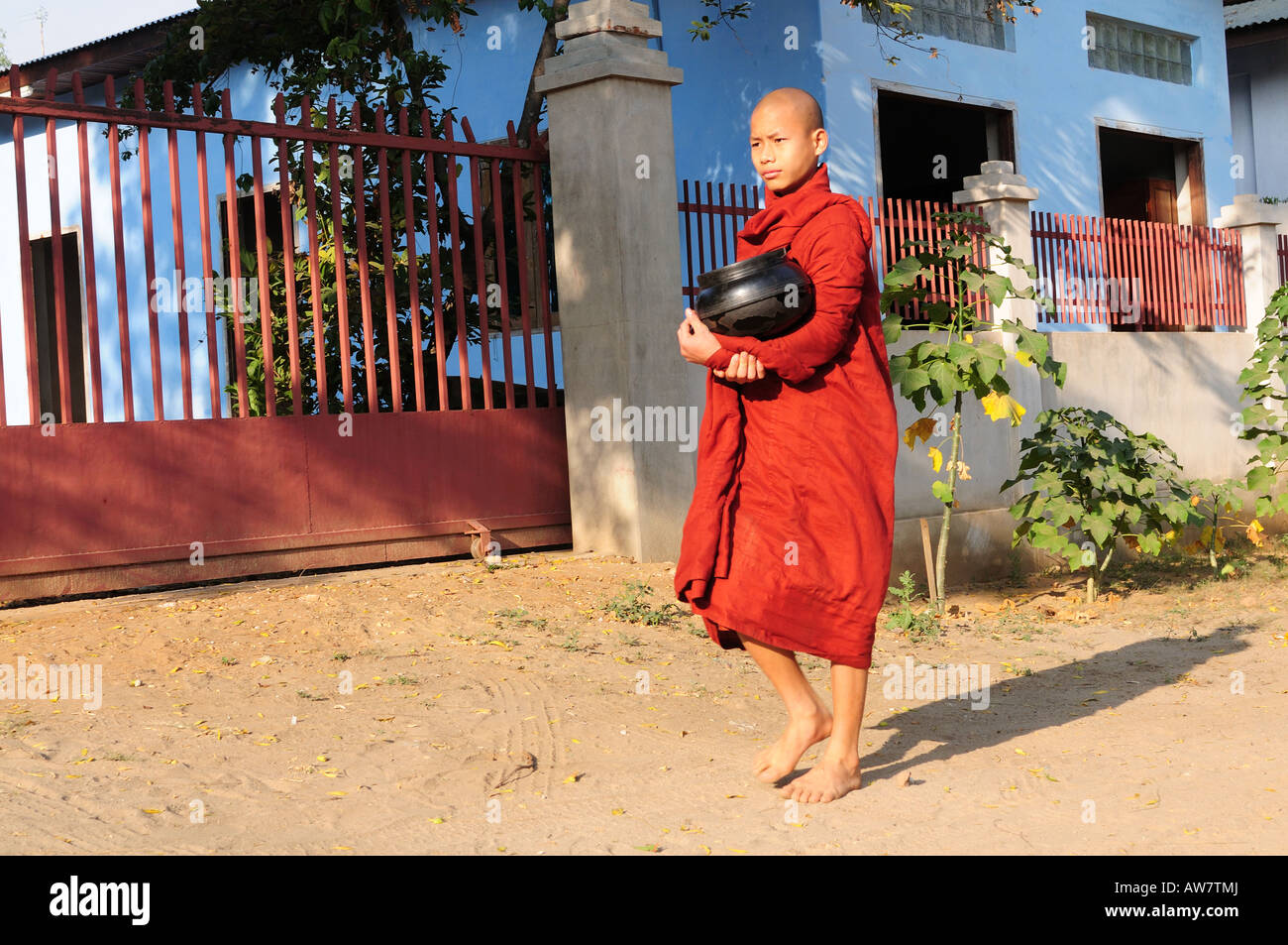 Young monk collects contributions from the people to have enough food for the day Bagan Myanmar Asia Stock Photo