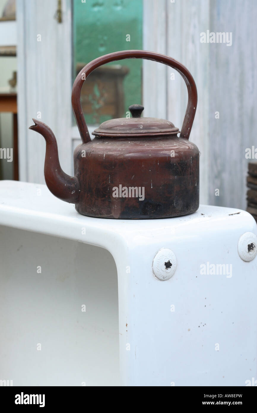 Old metal kettle on top of old ceramic kitchen sink at a building