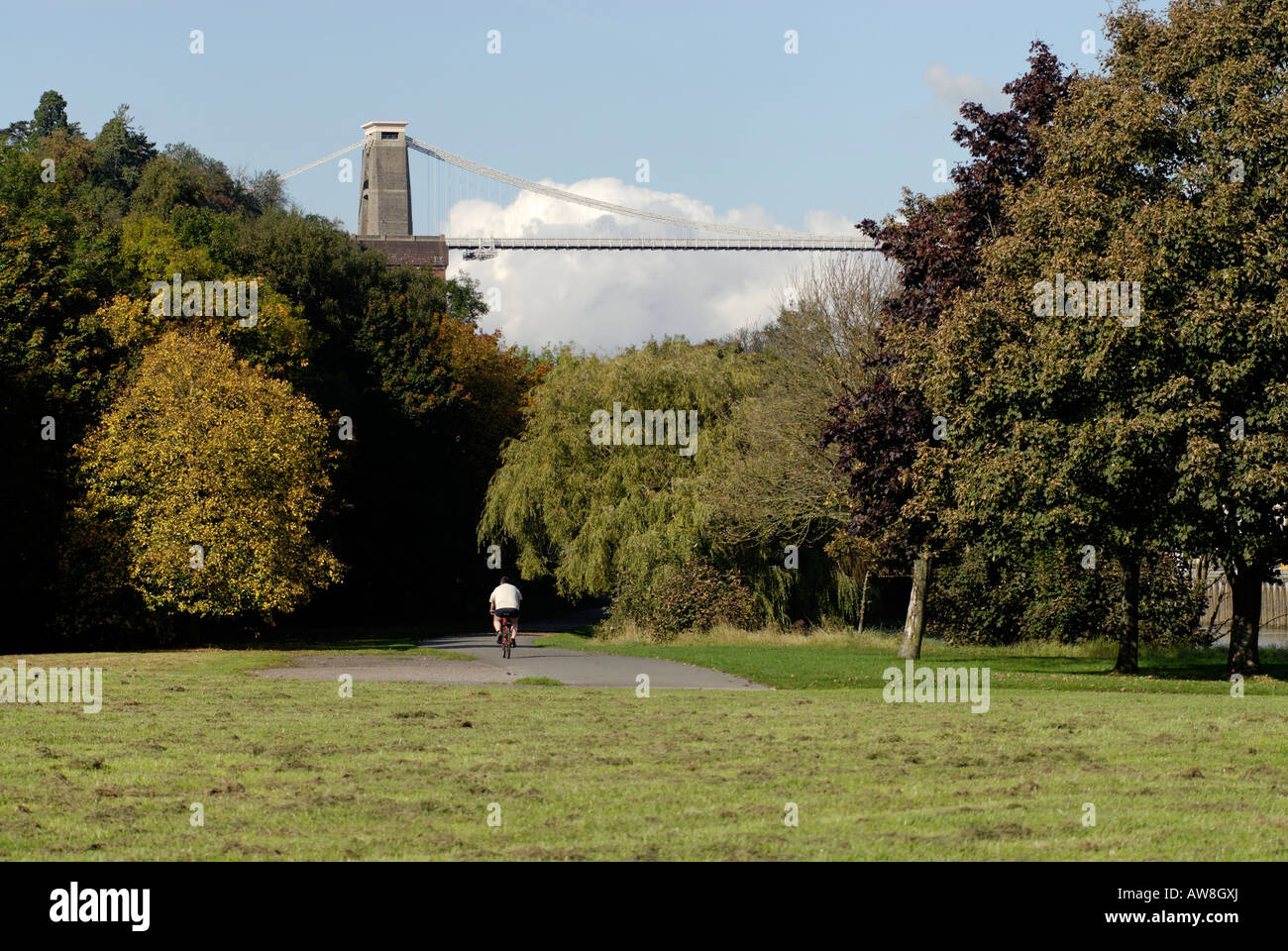 Fat cyclist on a cycle path in Bristol in the late summer with Clifton suspension bridge in the background. Stock Photo