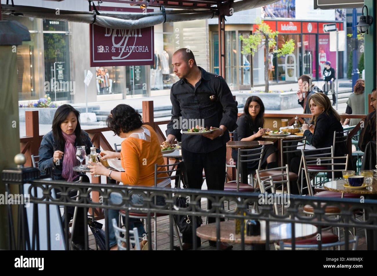 Woman cleaning up spilt drink with people looking on (sequence of 2 images) Stock Photo