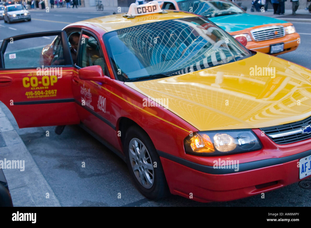 Man quickly getting into a taxi cab downtown Toronto, Ontario, Canada
