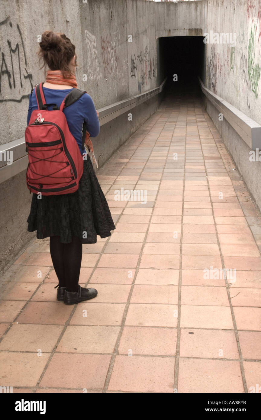 A young woman hesitating before entering a dark tunnel in Prague Czech Republic EU Stock Photo