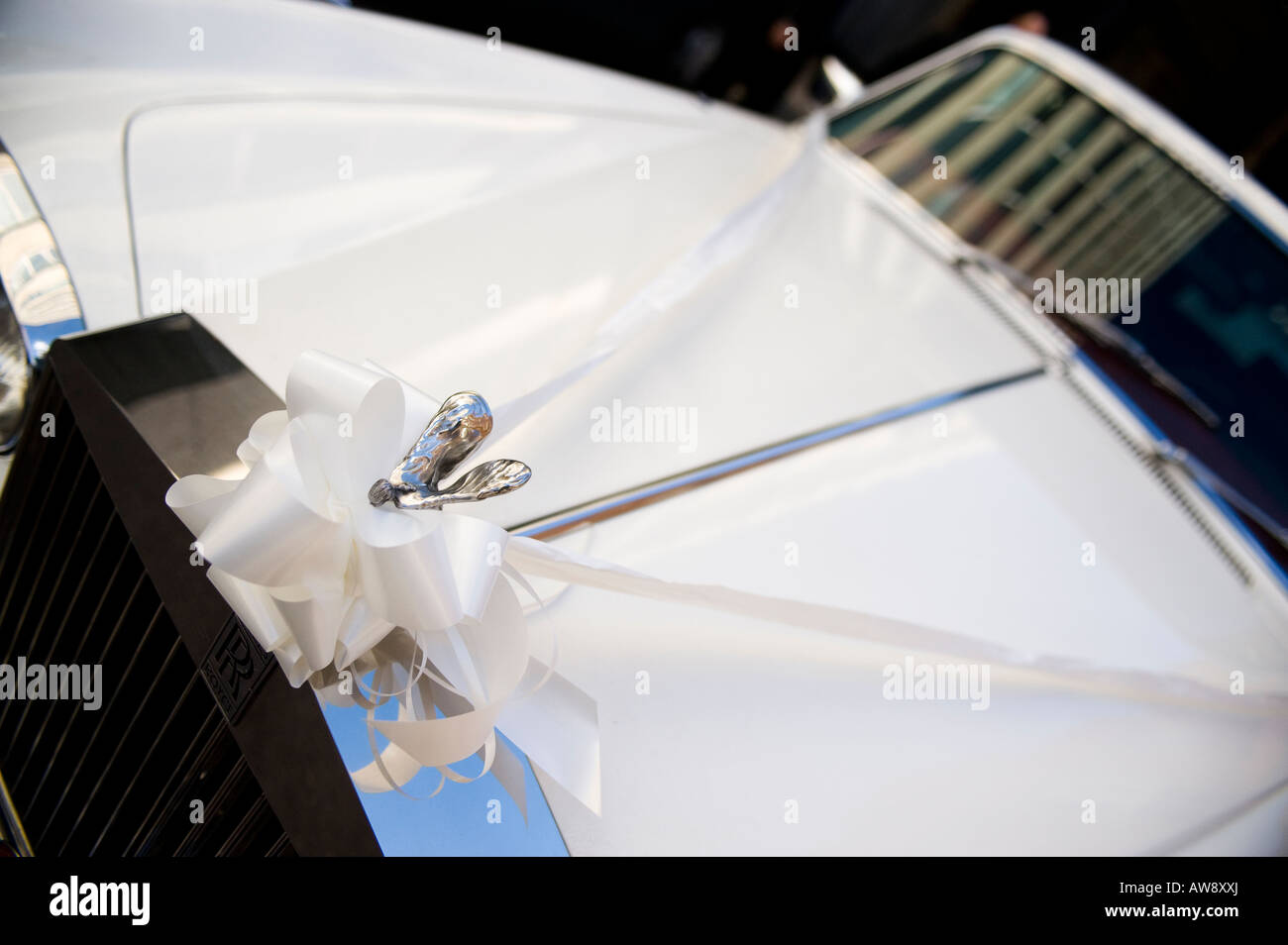 The front of a white rolls royce silver shadow II wedding car with white ribbon attached Stock Photo