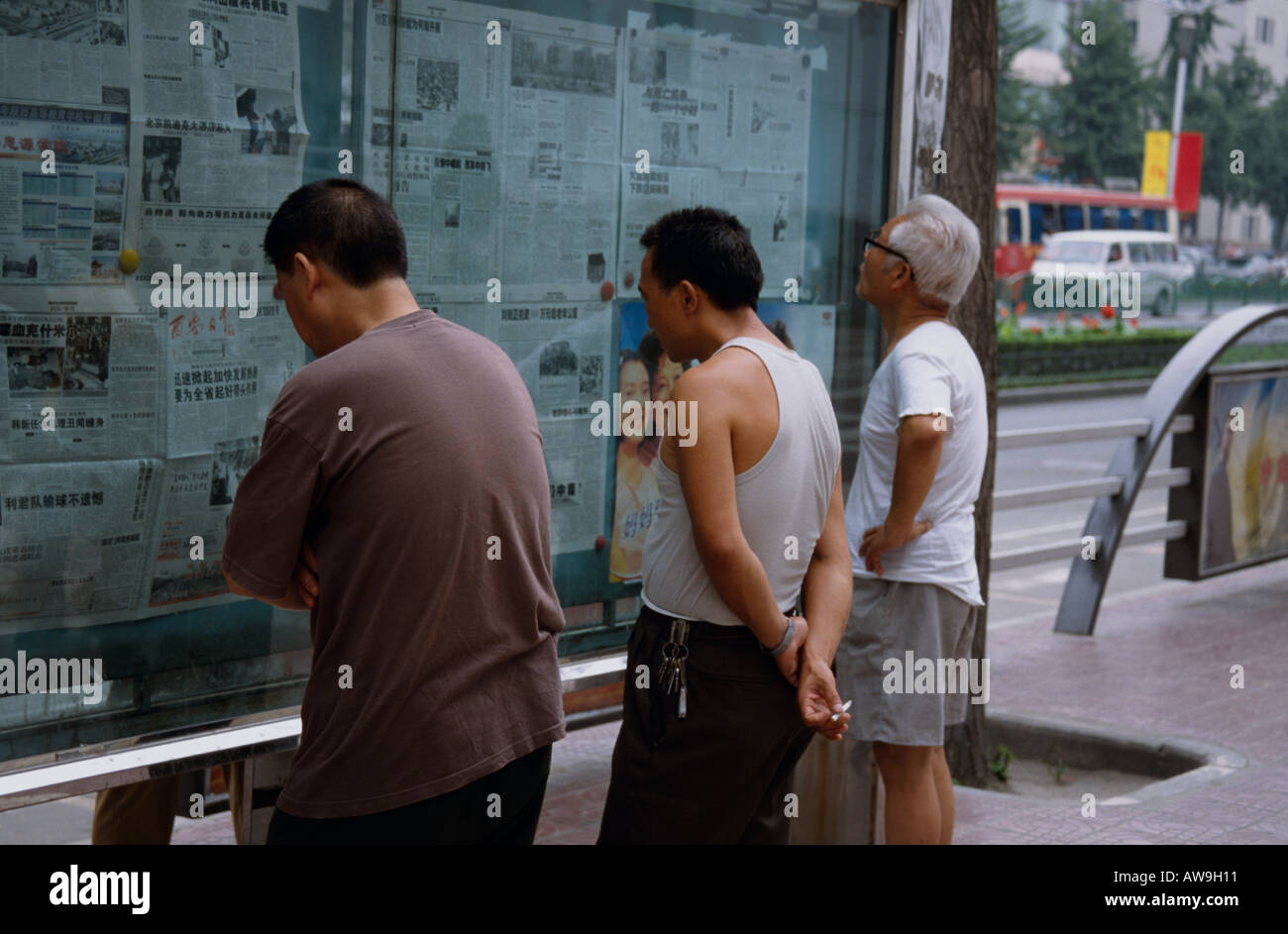 Perusing the local papers on the streets of Chengdu, China Stock Photo