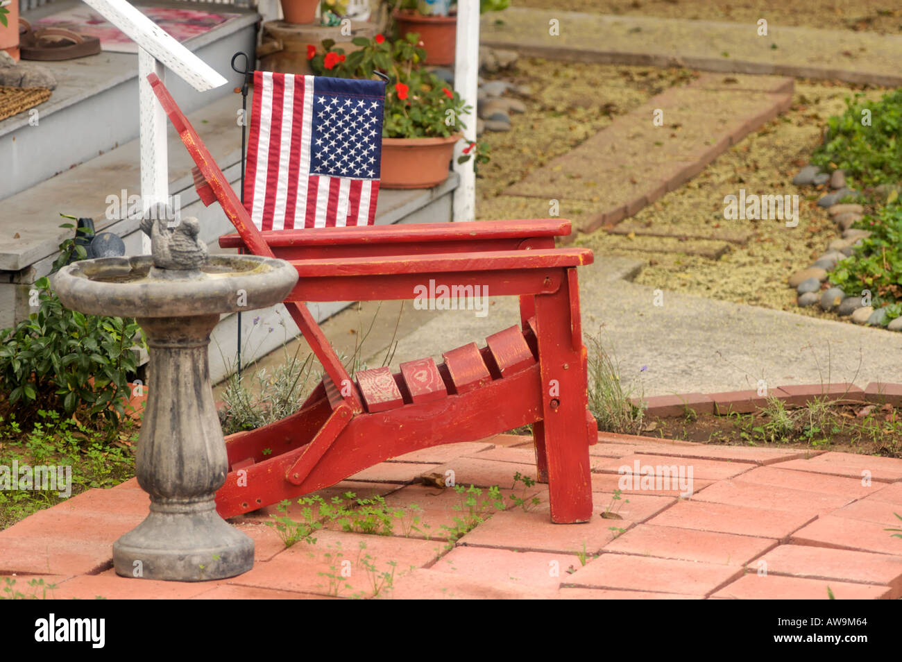 A red wooden Adirondack chair in front yard of a house in Encinitas, California, USA Stock Photo