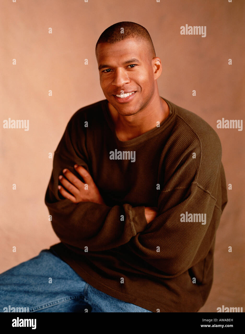 A young good looking African American man smiling in a studio portrait in casual clothing. Stock Photo