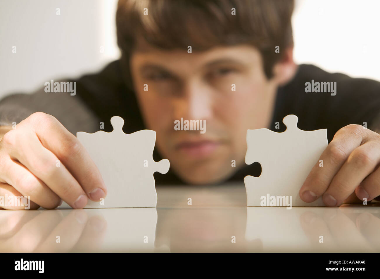 Men putting puzzle pieces together hires stock photography and images
