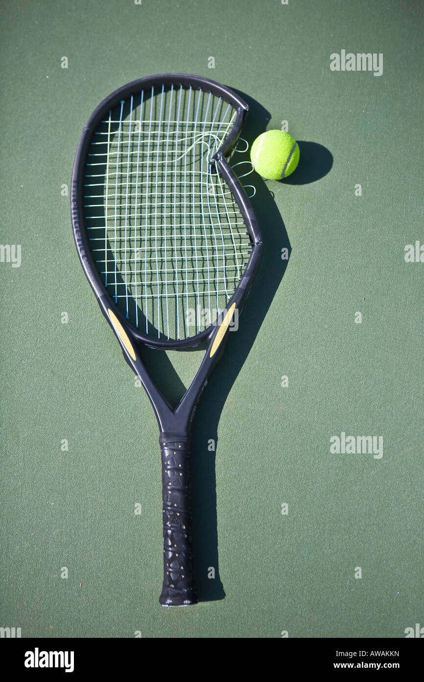 Broken tennis racket on green court with tennis ball Stock Photo Alamy