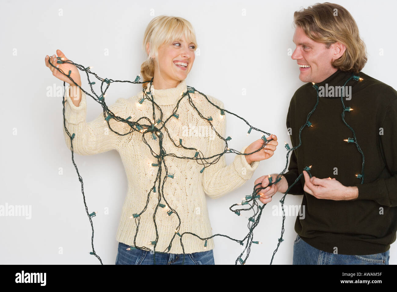 Couple untangling holiday lights Stock Photo Alamy
