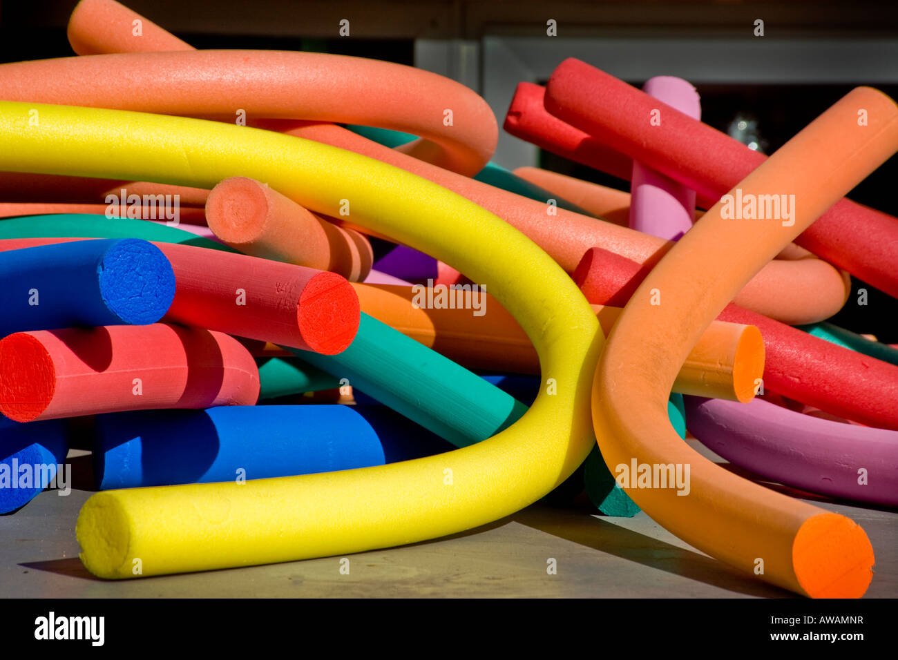 Coloful foam rubber swimming pool floats lie in a bright tangle Stock Photo