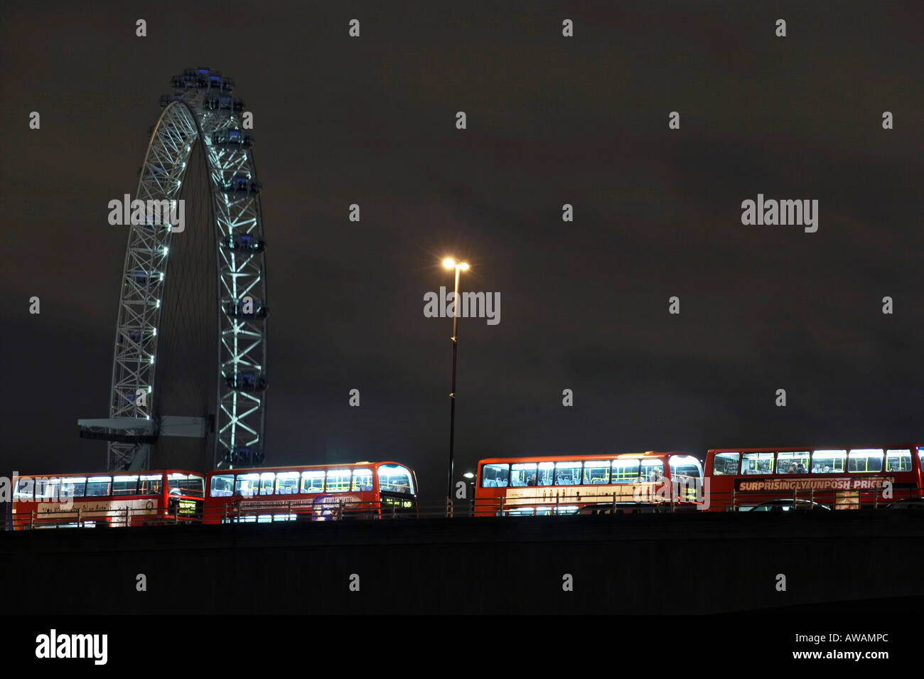 London Eye at night and a queue of Buses on Waterloo Bridge Stock Photo