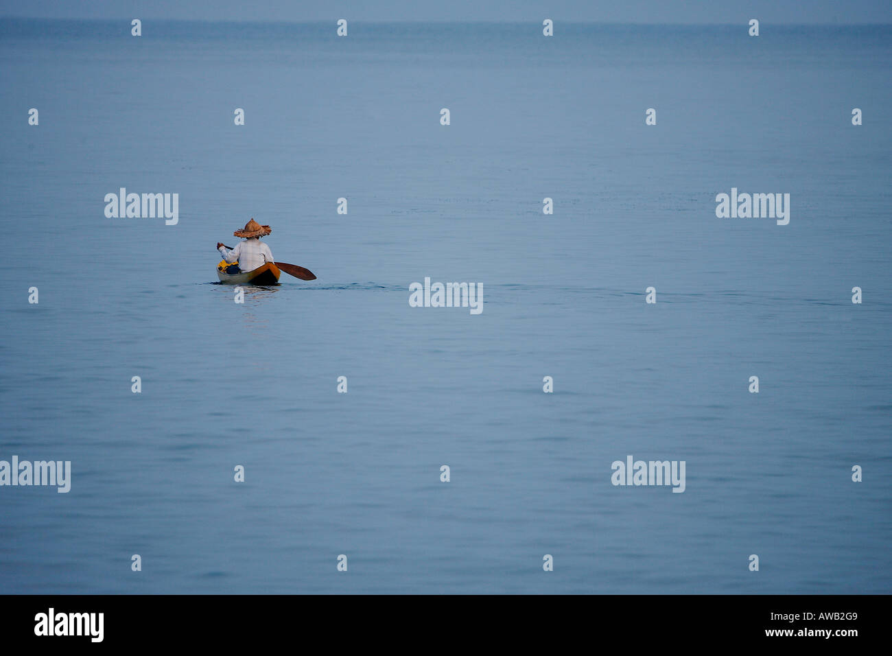 Man paddling a traditional Indonesian canoe in the Mentawai Islands Stock Photo