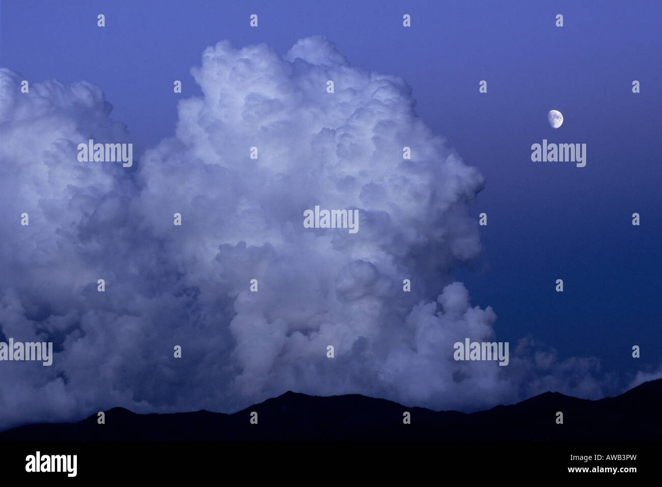 Storm clouds over mountains with moon Stock Photo - Alamy