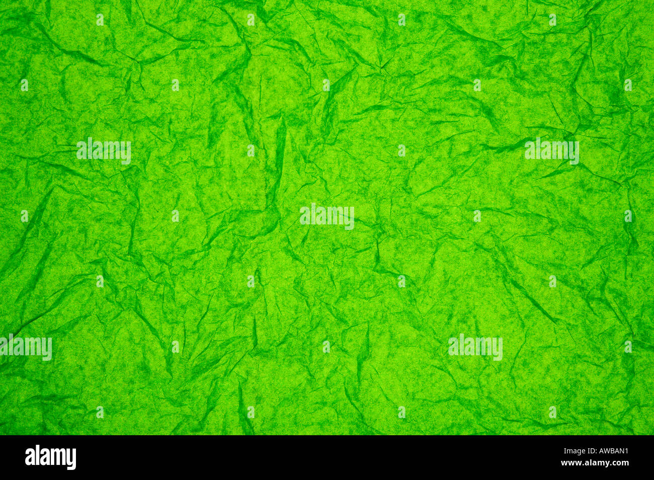 ABSTRACT RANDOM BACKGROUND OF CREASED CRUMPLED BRIGHT GRASS GREEN TISSUE PAPER Stock Photo